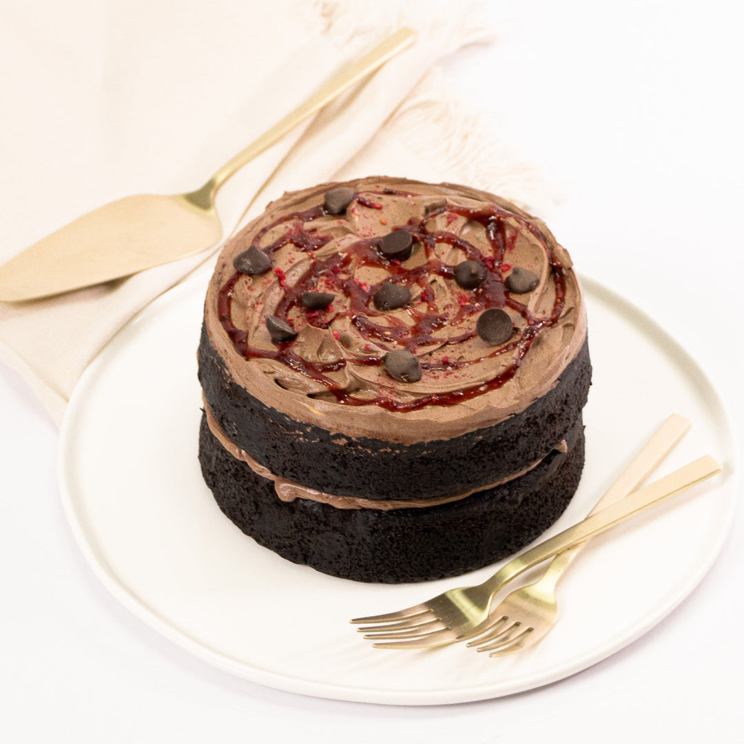 Gluten free vegan chocolate cake with raspberry coulis and silky buttercream.