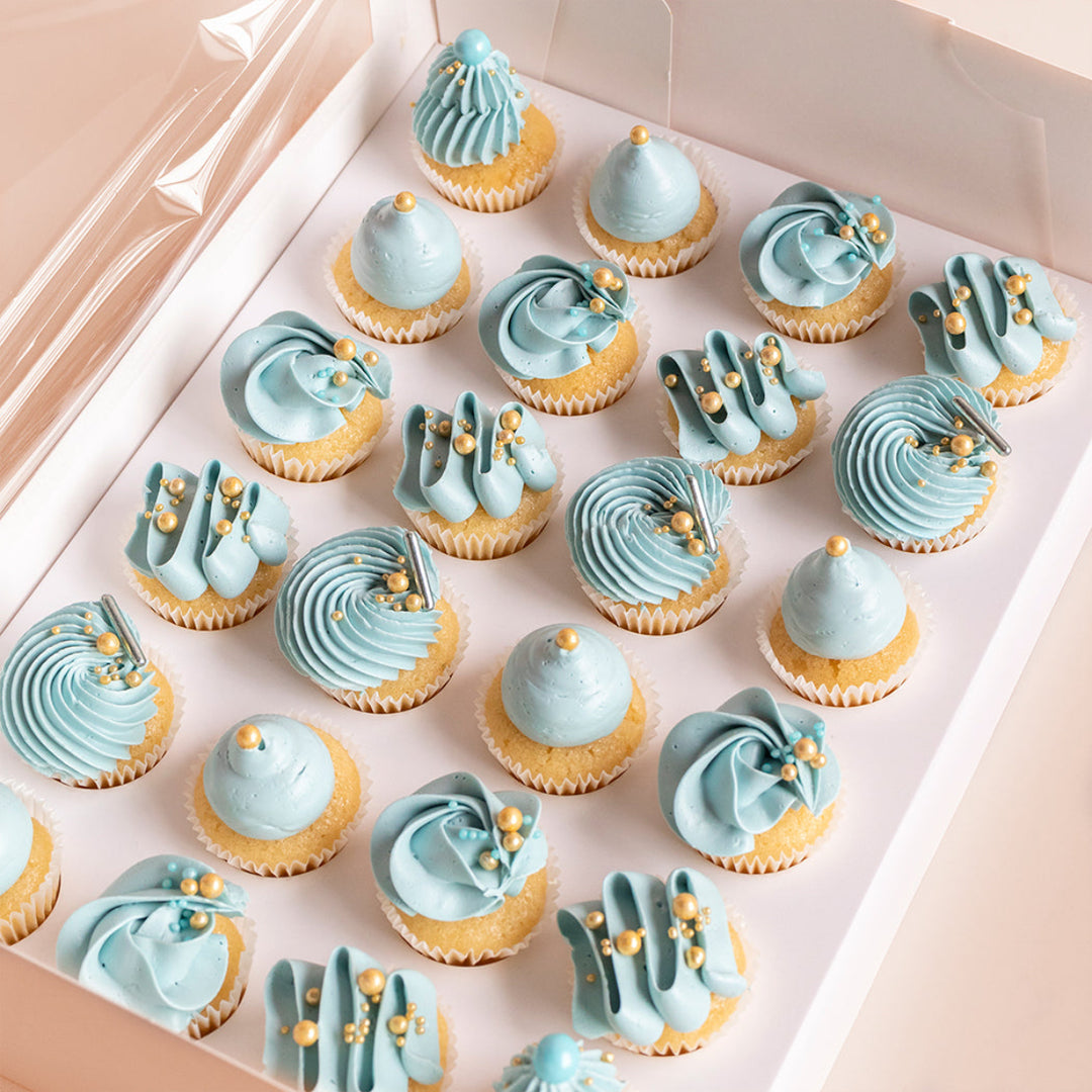Mini custom cupcakes with piped vanilla meringue buttercream and coloured designs.