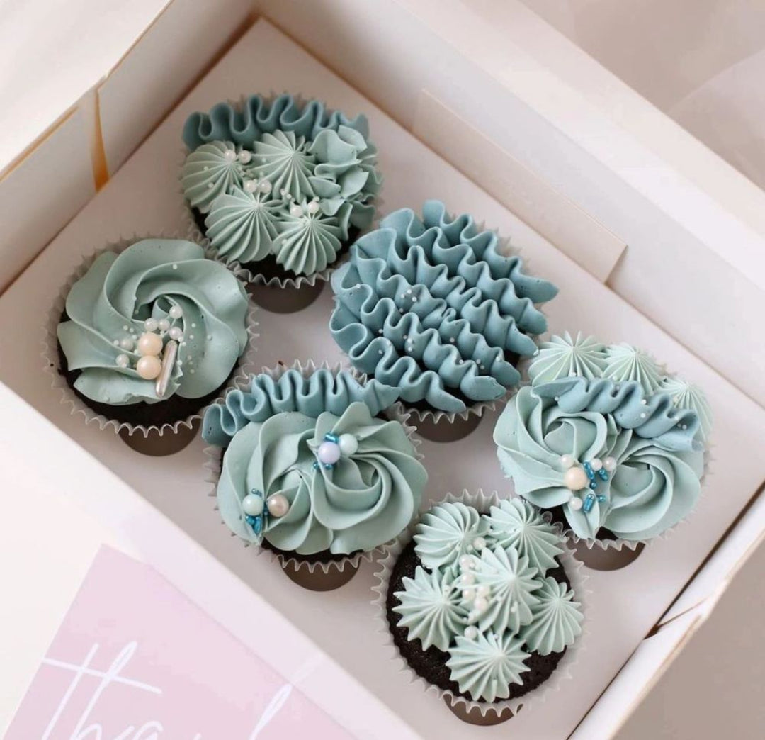 Custom cupcakes with piped vanilla meringue buttercream in chosen colours.