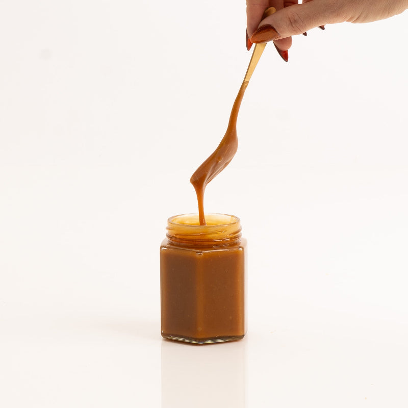 Golden caramel sauce in a jar — rich, velvety, and indulgent.