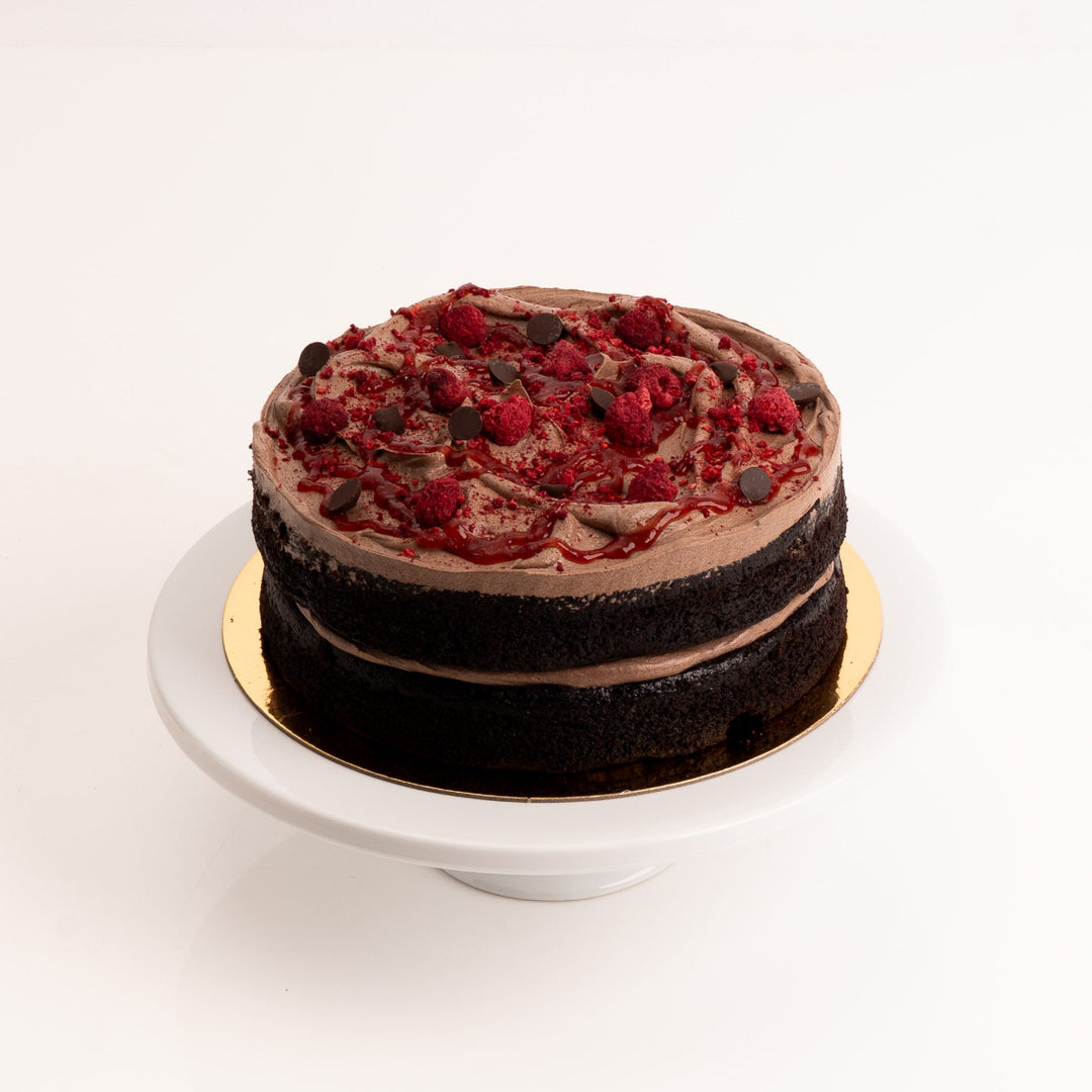 Vegan chocolate raspberry cake with rich chocolate buttercream and raspberry swirl.