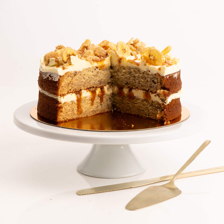 Slice of moist banana cake with cream cheese frosting and caramel drizzle by Sweet Talk, available for delivery in Auckland.
