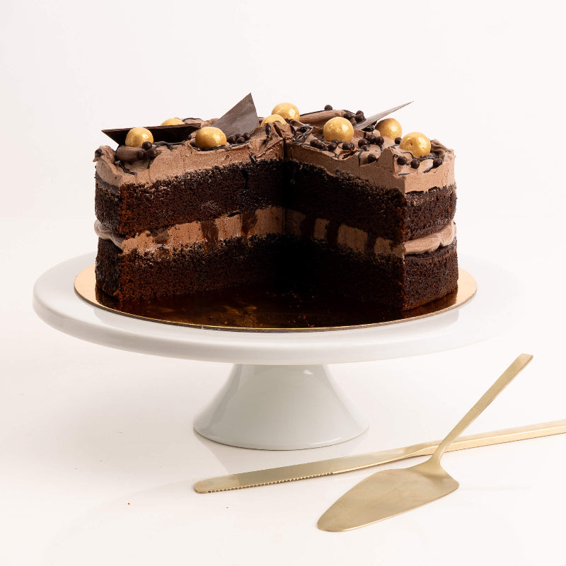 Rich chocolate layer cake topped with curls and creamy frosting.