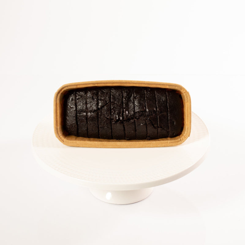 Moist vegan chocolate loaf cake topped with glossy chocolate glaze.