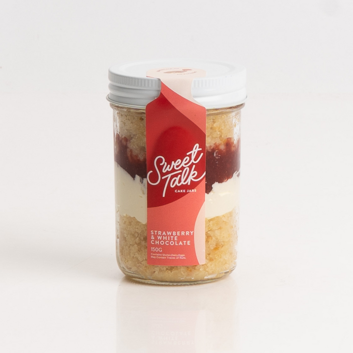Layered strawberry and white chocolate dessert in a cake jar.