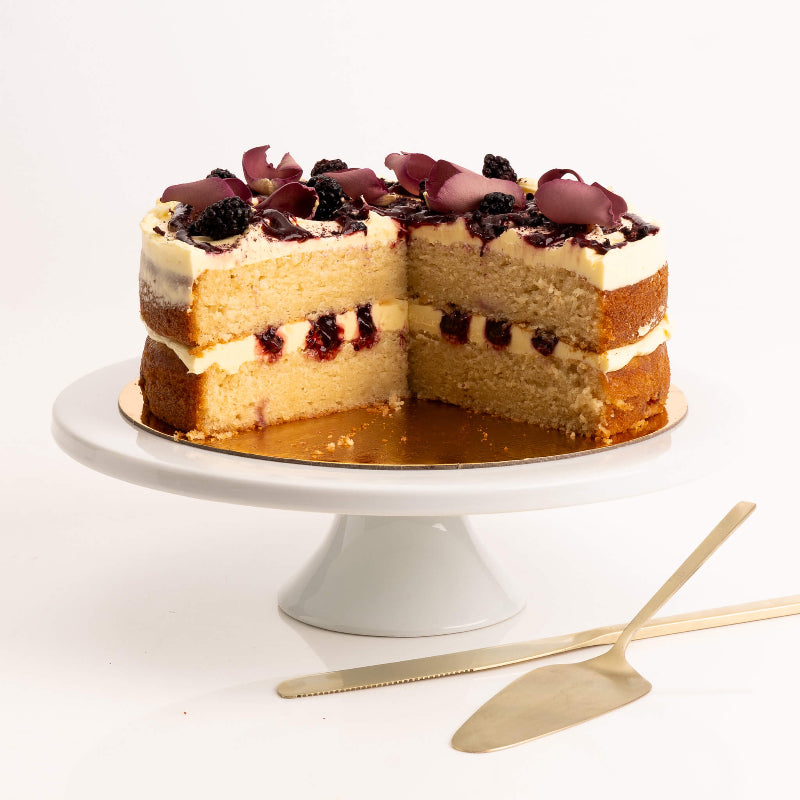 Slice of vanilla cake with blackberry layers and cream frosting.