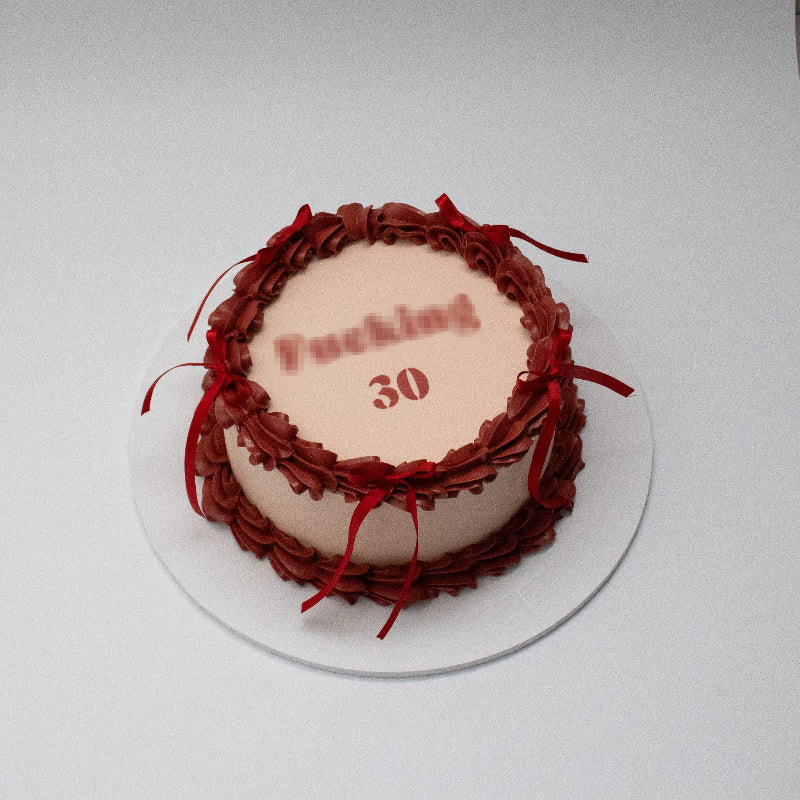 Single-tier vintage cake with intricate piping and bows.