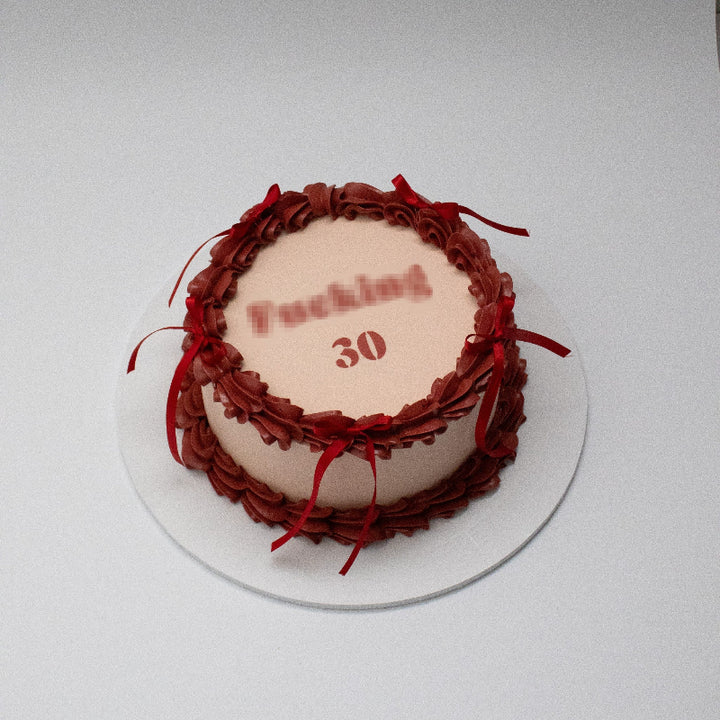 Single-tier vintage cake with intricate piping and bows.