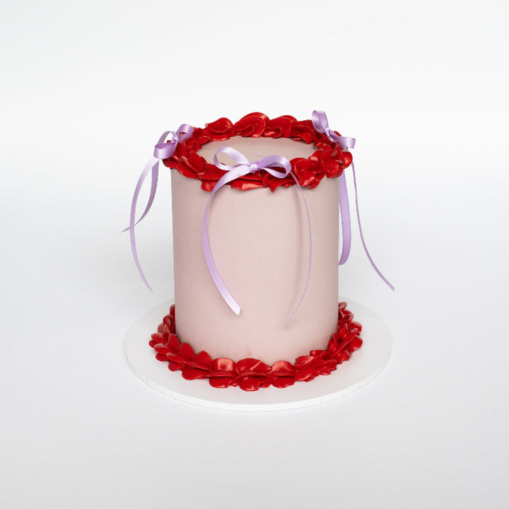 Elegant celebration cake with vintage piped details and sprinkles.