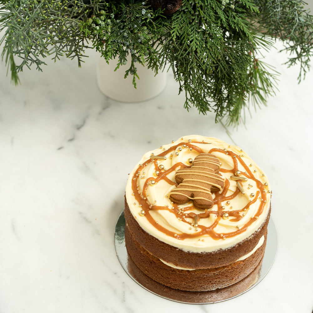 Gingerbread cake with cream cheese buttercream, spiced caramel, gold shimmer and Caramilk gingerbread man