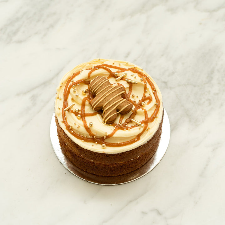 Gingerbread cake with cream cheese buttercream, spiced caramel, gold shimmer and Caramilk gingerbread man.