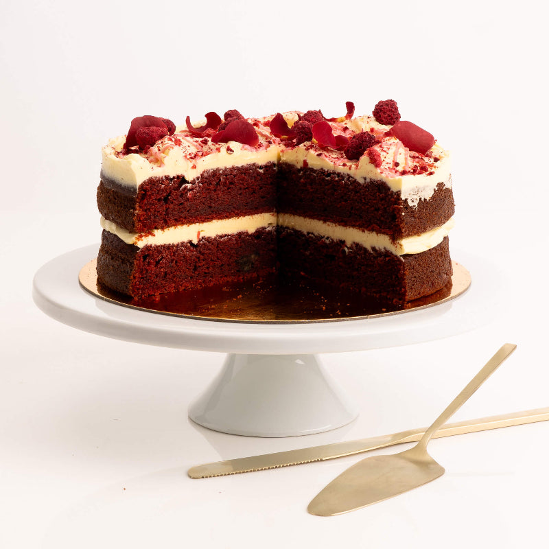 Red velvet sponge topped with creamy white icing and cocoa dust.