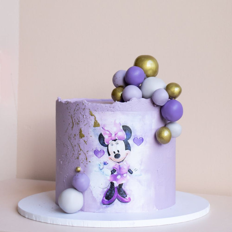 Playful themed cake with edible image and coloured chocolate decorations.